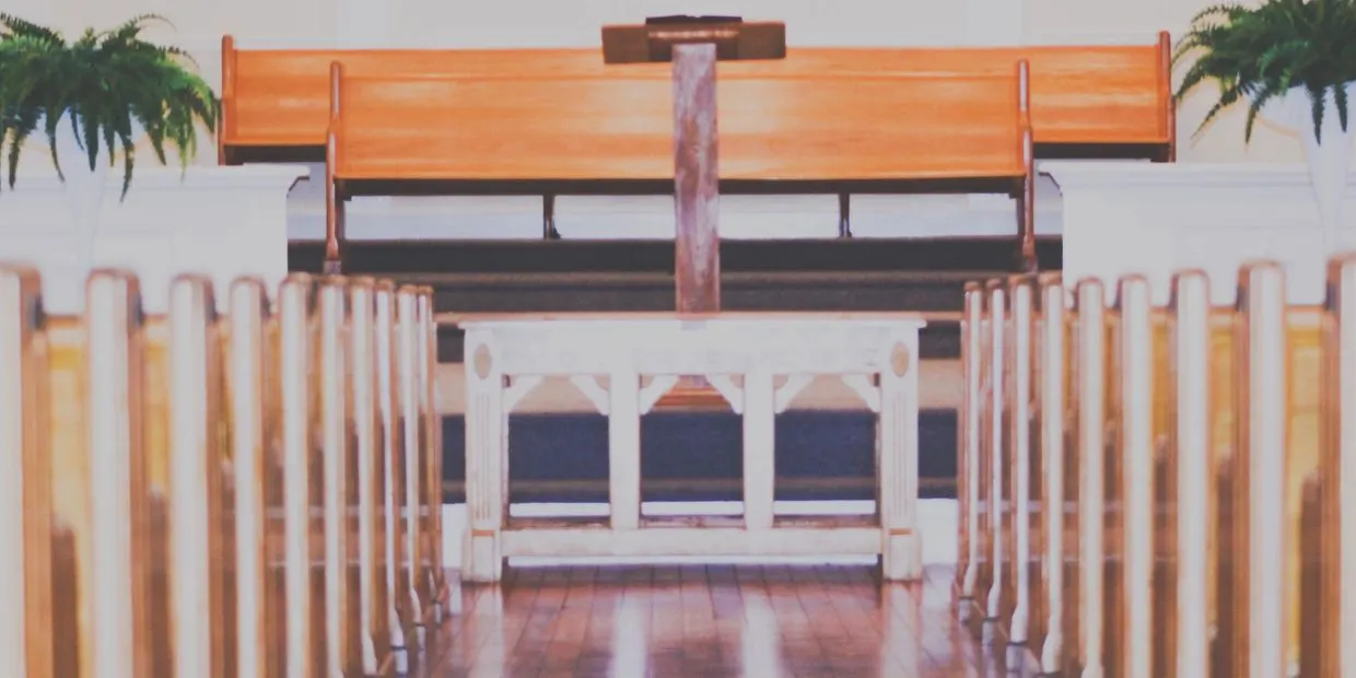 Church pews with a wooden cross at the altar